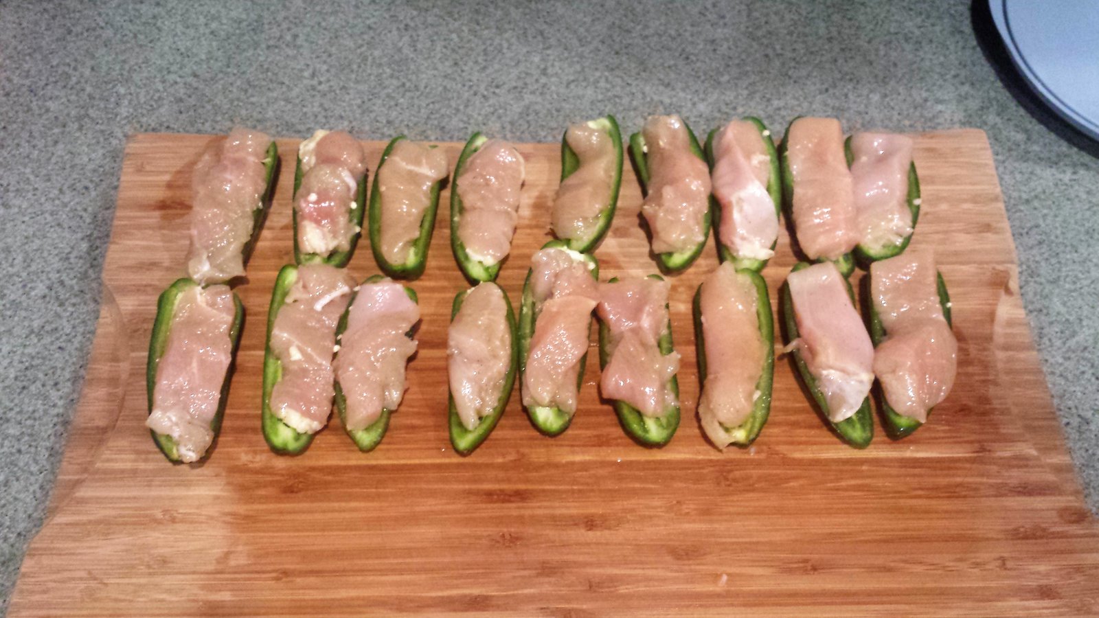 Here is the chicken strips placed inside the jalapeno halves.