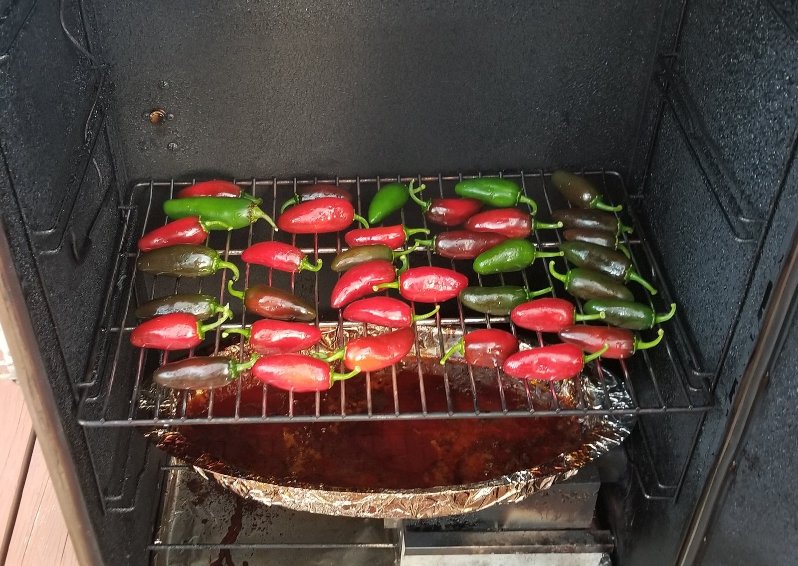 Jalapenos being put into the smoker.