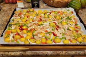The sheet pan ready to go into the oven with the ingredients spread out evenly.