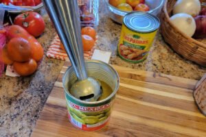 Immersion blender blending tomatillos in the can for chicken pozole verde.