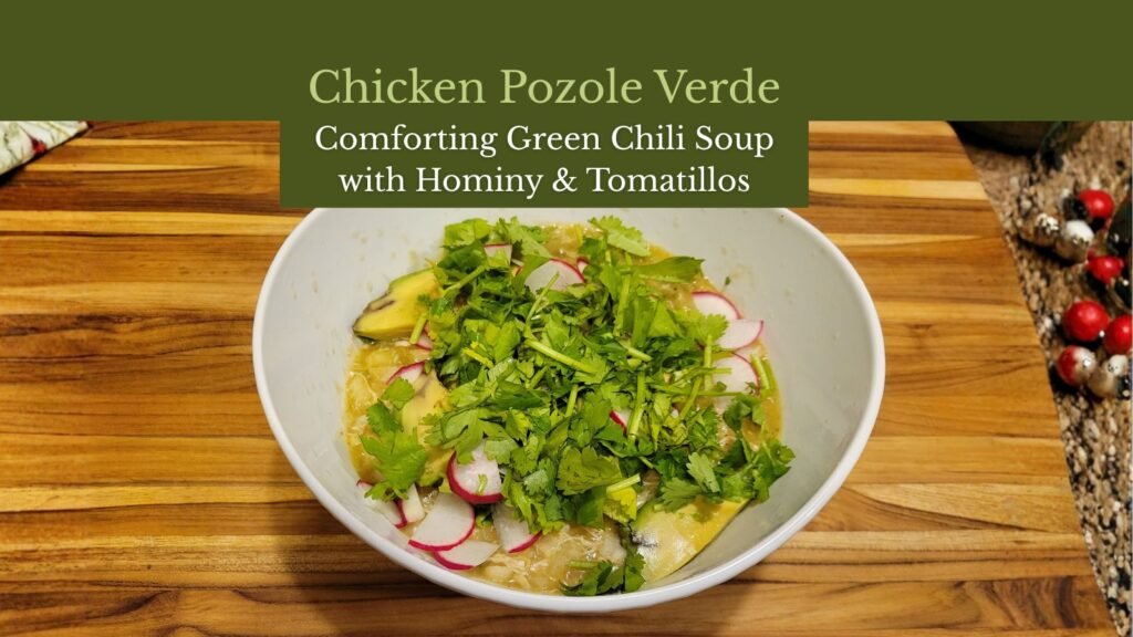 Bowl of chicken pozole verde topped with cilantro, radishes, and avocado slices.