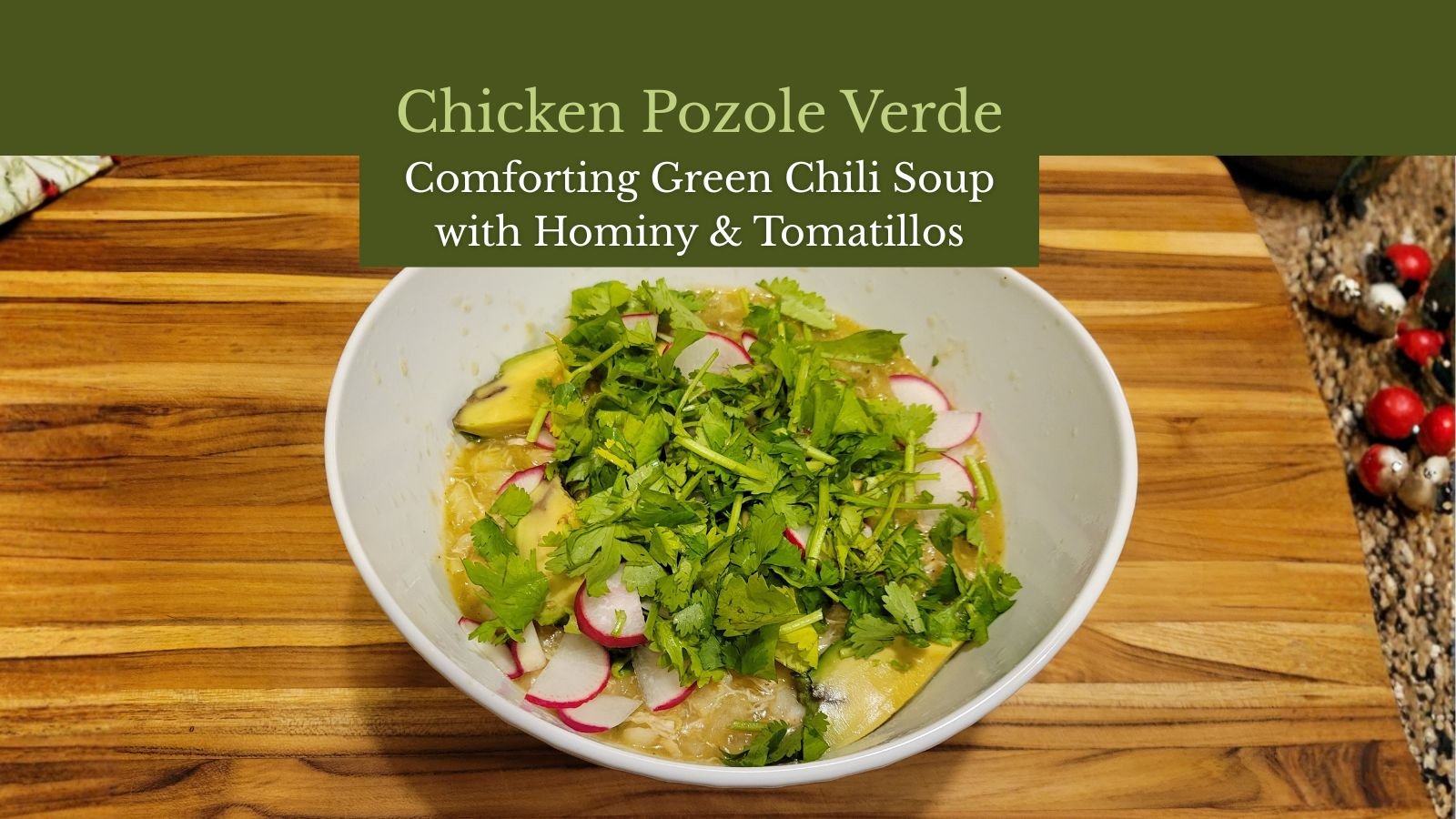 Bowl of chicken pozole verde topped with cilantro, radishes, and avocado slices.