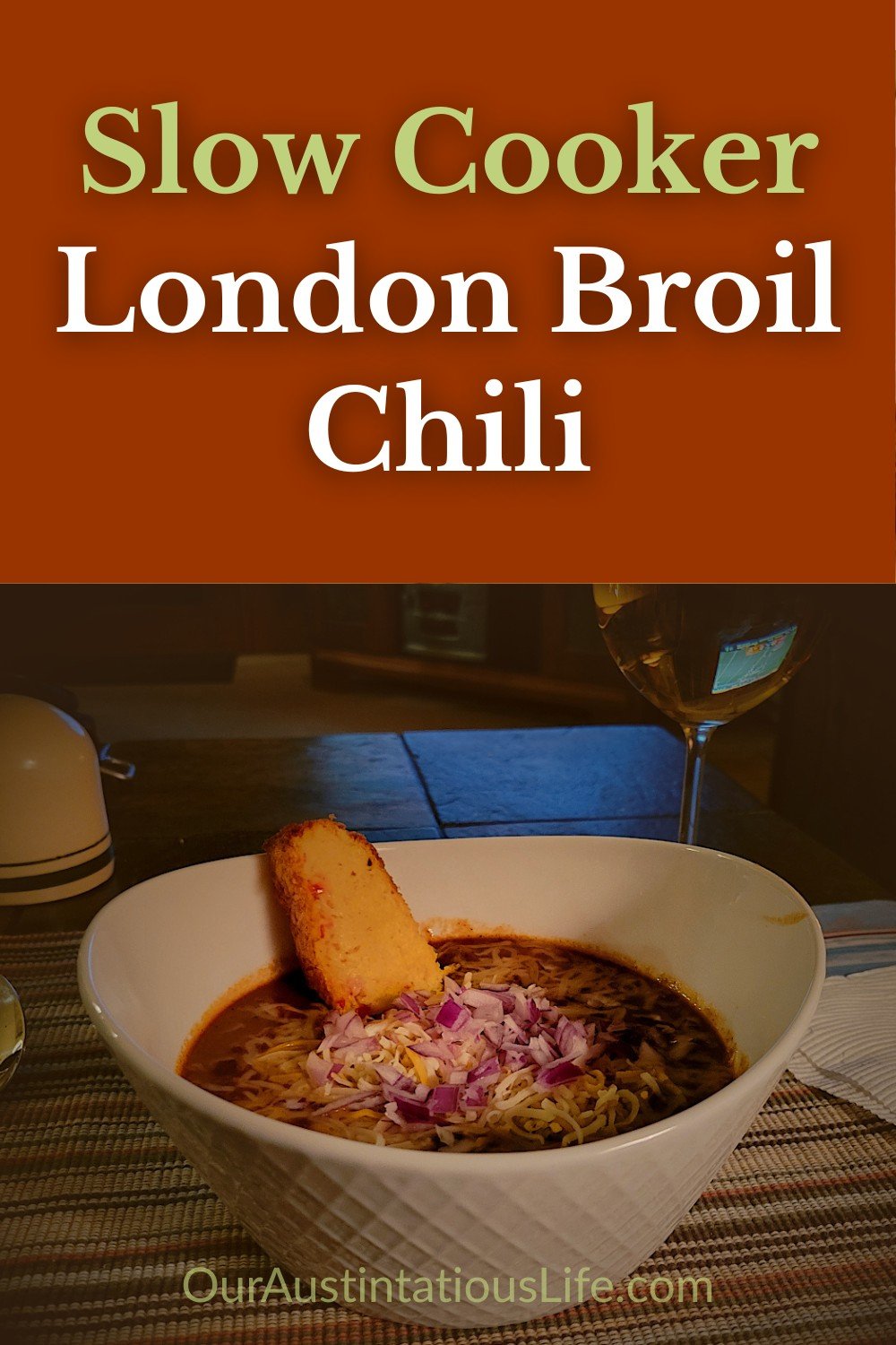 Pinterest graphic for Slow Cooker London Broil Chili, showing a cozy bowl of chili with cheese, onions, and cornbread, styled with warm orange and olive tones.